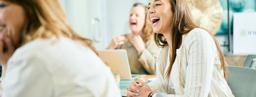 Group of coworkers laughing together at a table