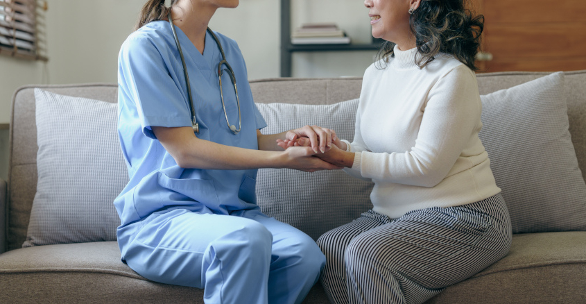 Nurse holding hands with elderly patient