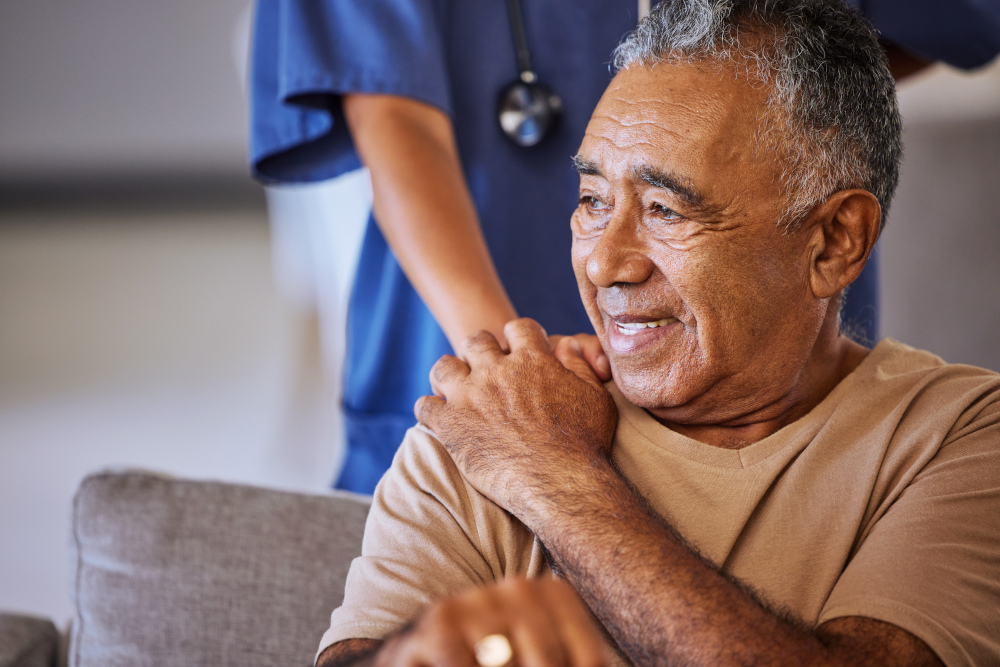 Nurse placing hand on elderly patient's shoulder
